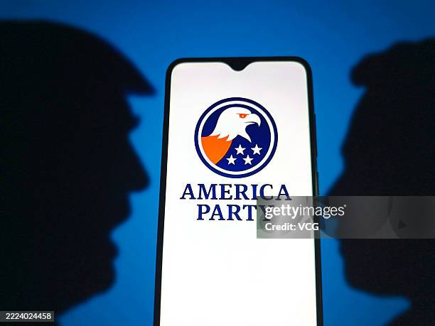 In this photo illustration, the sign of the 'America Party' is displayed on a smartphone screen with the silhouettes of Donald Trump and Elon Musk in...