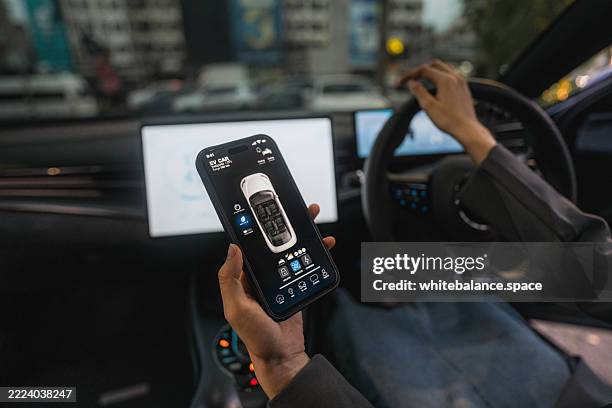 a woman using the ev car's app while driving home - location tracking stock pictures, royalty-free photos & images