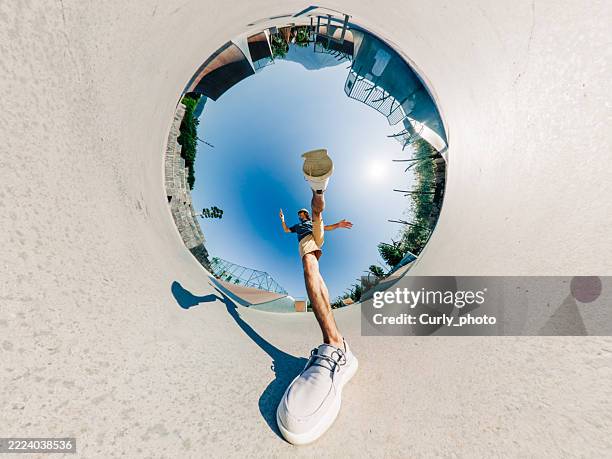 a man takes a big step while walking in the park. fisheye lens photo. - digital native stock pictures, royalty-free photos & images