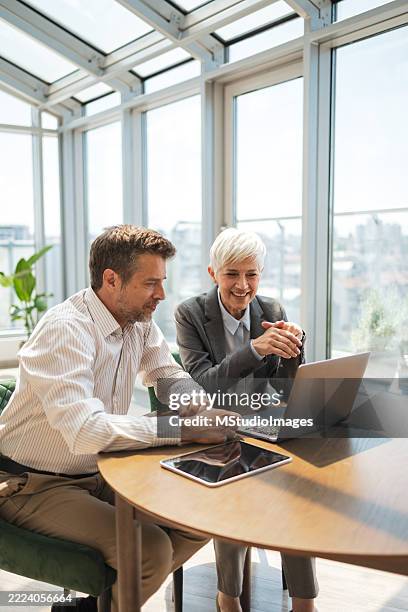 professional meeting in a bright office with two colleagues collaborating - performance review stock pictures, royalty-free photos & images