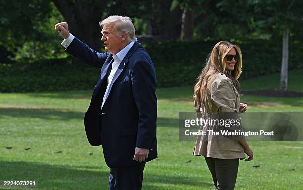 President Trump makes a fist gesture toward a crowd on the South Lawn at the White House. He and First Lady Melania Trump then made their way toward...