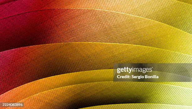 curved overlapping paper sheets with a gradient from red to yellow in textured patterns. 3d rendering - matte background stock illustrations