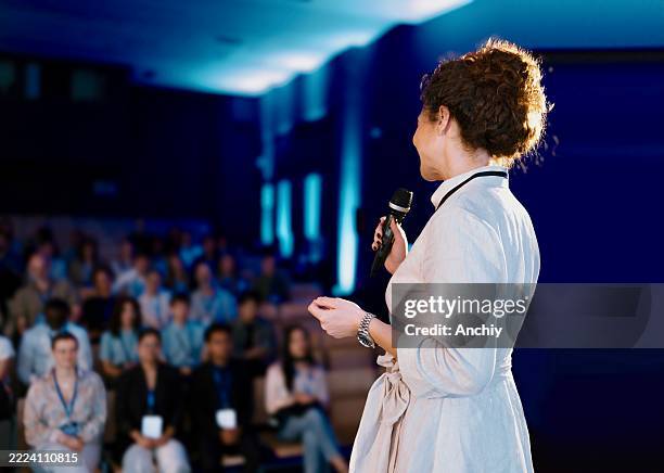 rear view of the conference speaker giving talk at conference event - auditorium stock pictures, royalty-free photos & images