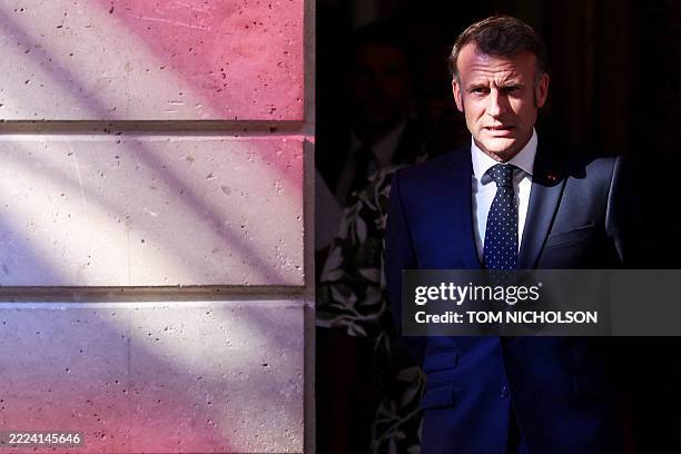 French President Emmanuel Macron walks through a door on the day of a meeting with New Caledonia's elected officials and state representatives at the...