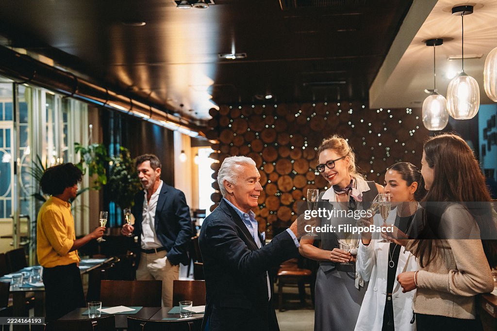 Business people toasting with champagne flutes at a corporate event in a restaurant