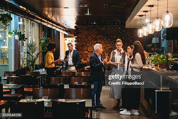 colleghi che bevono un drink insieme dopo il lavoro in un ristorante - happy hour foto e immagini stock
