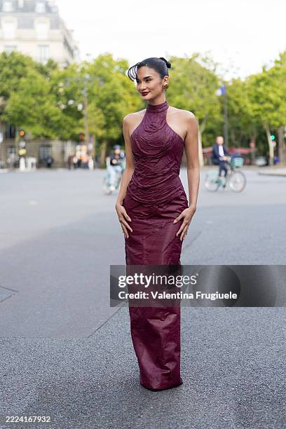 Pia Wirtzbach wears a ruched, high-neck sleeveless gown in deep burgundy with a floor-length silhouette and a fitted bodice outside the Ashi Studio...