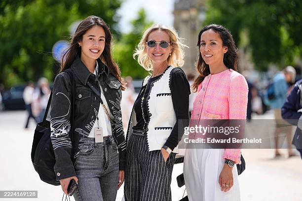 Guest wears a black denim jacket featuring white abstract line patterns and silver buttons. Underneath, a white top is visible. The outfit includes...
