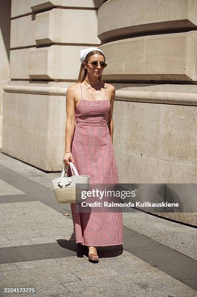 Julia Comil wears red and white checkered maxi dress with straps, white head scarf, sunglasses and beige and white bag during the Haute Couture...