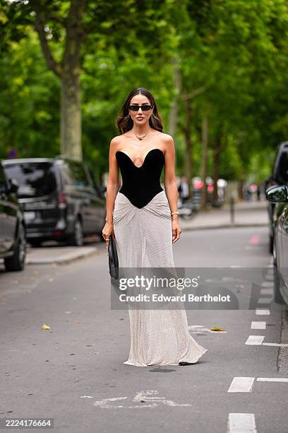 Tamara Kalinic wears a strapless dress featuring a black velvet bodice with a deep sweetheart neckline. The skirt is made of a shimmering, textured...