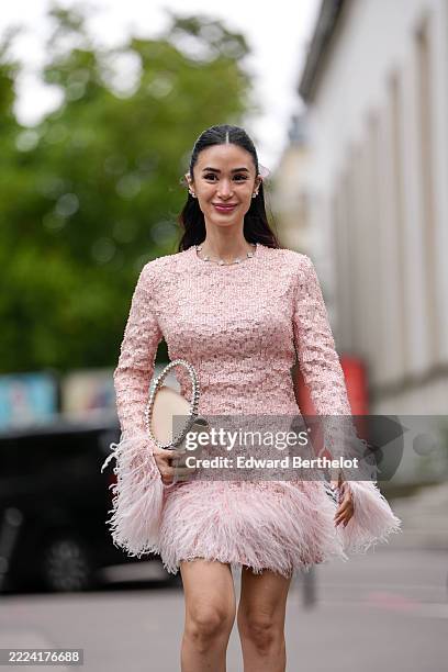 Heart Evangelista wears a textured pink dress from Tamara Ralph featuring long sleeves and a fitted silhouette. The dress is adorned with feather...