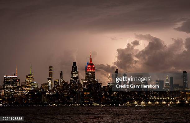 Lightning from a storm passing over Long Island Sound silhouettes the skyline of midtown Manhattan and the Empire State Building in New York City on...