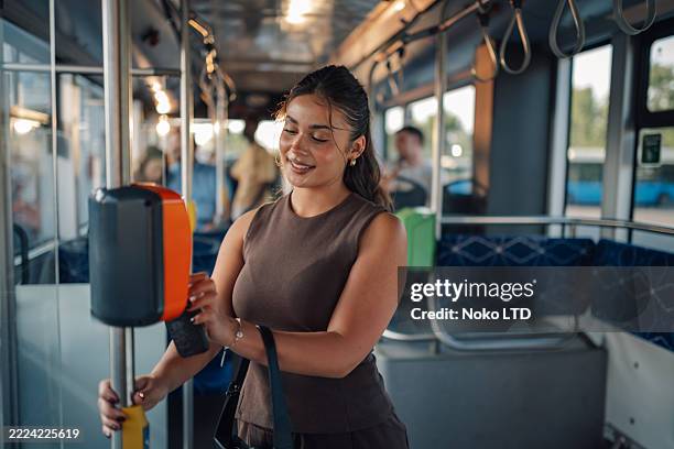 young woman paying bus fare with contactless payment - validation stock pictures, royalty-free photos & images