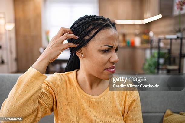 mujer rascándose la cabeza, sufriendo problemas de cabello y cuero cabelludo - cuero cabelludo fotografías e imágenes de stock