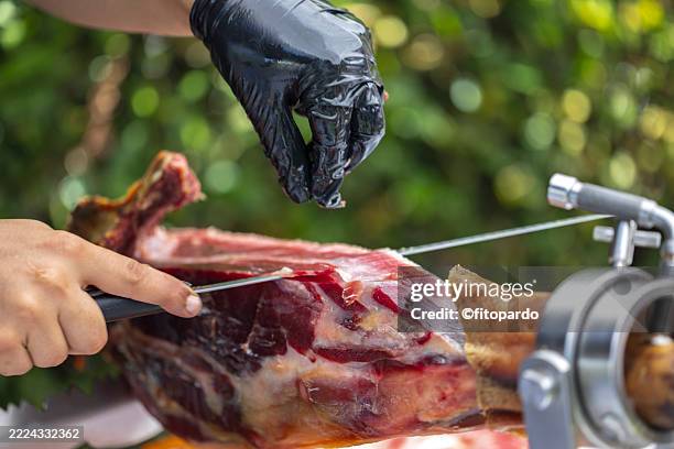 gourmet iberico ham being hand-cut outdoors - ham knife stock pictures, royalty-free photos & images