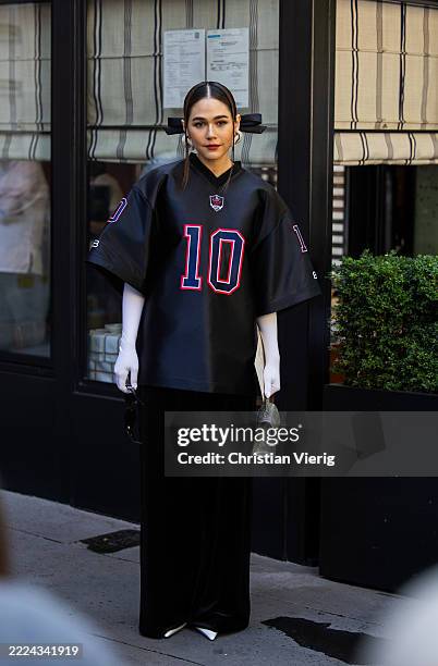 Araya Alberta Hargate wears football jersey, white gloves, silver bag outside Balenciaga during the Haute Couture Fall/Winter 2025/2026 as part of...