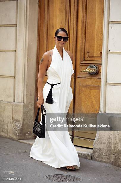 Gili Biegun wears long white maxi dress with big and long collar, black tassel belt and black sunglasses outside Viktor&Rolf show during the Haute...