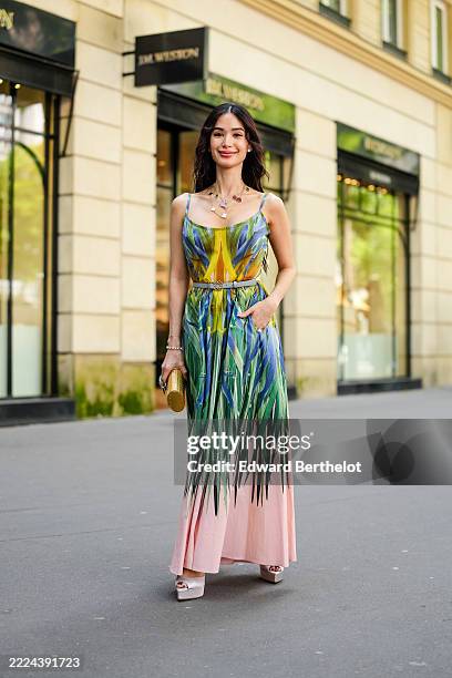 Heart Evangelista wears a sleeveless maxi dress featuring a vibrant multicolored print with green, blue, and yellow hues on the bodice, transitioning...
