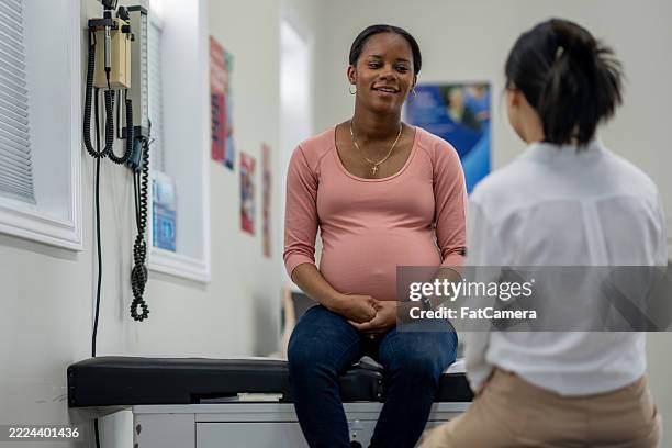 médico consultor de mujer embarazada en clínica médica para chequeo prenatal - comadrona fotografías e imágenes de stock
