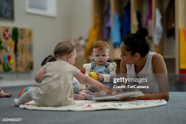 teacher engaging with children during playtime in a colorful classroom environment - child care worker stock pictures, royalty-free photos & images