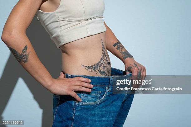 young woman losing weight - young woman jeans side view stock pictures, royalty-free photos & images