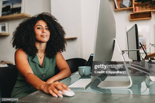 confident young businesswoman working from home using desktop computer - using computer mouse stock pictures, royalty-free photos & images
