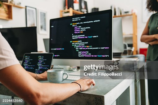 Software developer writing code on computer and tablet in the office Software developer writing code on computer and tablet in the office