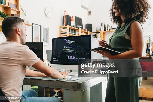 Software developers reviewing code on computer in the office Software developers reviewing code on computer in the office