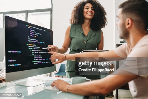 Computer programmers working together on a software project Computer programmers working together on a software project