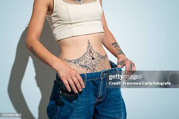 young woman losing weight - young woman jeans side view stock pictures, royalty-free photos & images