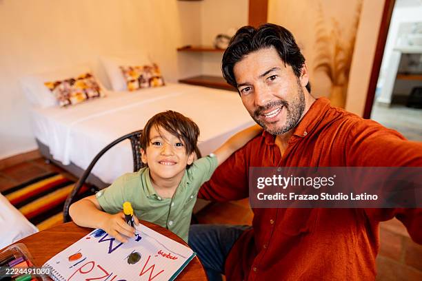 father takes a selfie as he and his child create a heartfelt mother’s day message together at home - camera point of view - camera point of view stock pictures, royalty-free photos & images