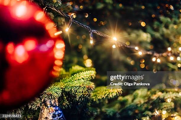 christmas tree decorated with red baubles and sparkling lights - ljusslinga bildbanksfoton och bilder