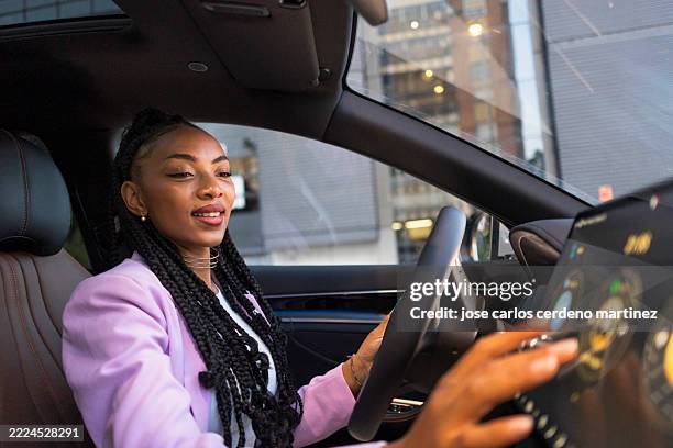businesswoman driving modern car and using touchscreen navigation system - fahrerloses auto stock-fotos und bilder