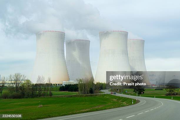 nuclear power plant cooling towers dominating rural landscape - radioactive contamination stock pictures, royalty-free photos & images