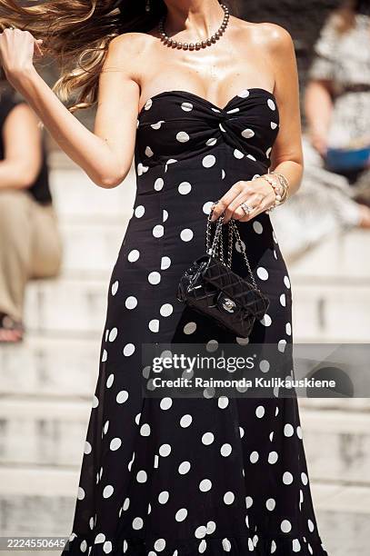 Guest wears strapless long maxi dress with white polka dots, blakc leather bag outside Peet Dullaert show during the Haute Couture Fall/Winter...