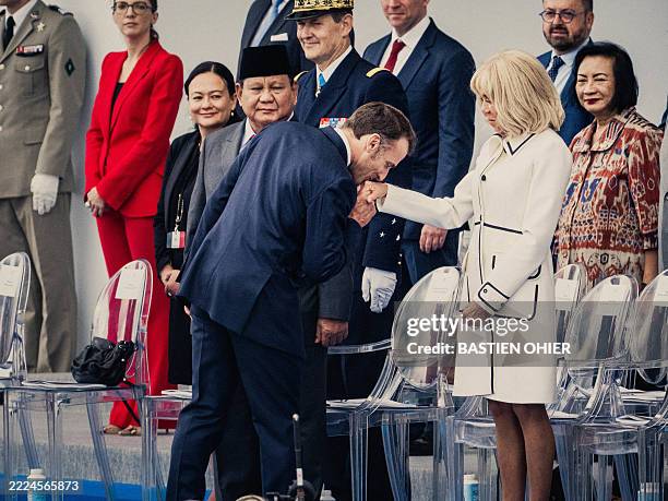 Emmanuel Macron president of the french republic kisses the hand of Brigitte Macron french first lady during the annual Bastille Day military parade...