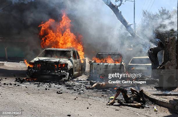 Public Security personnel killed in an attack by an Israeli Defence Force strike lie dead in front of burning trucks on July 15 , 2025 near Sweida,...