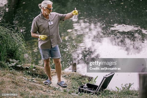 scientist collecting water samples for environmental analysis - scientific sample stock pictures, royalty-free photos & images
