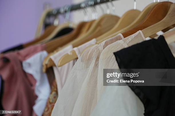 elegant chiffon dresses and blouses on clothing racks at the garage sale - blusa de cetim imagens e fotografias de stock