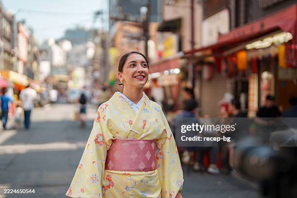 touriste vêtue d’un kimono et marchant et explorant la ville de tokyo - kimono photos et images de collection