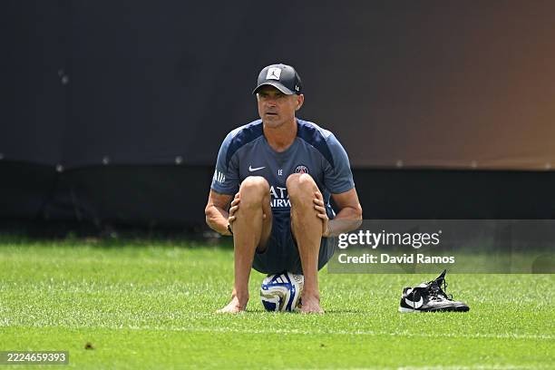 Luis Enrique, Head Coach of Paris Saint-Germain, looks on with his shoes off as he sits on an adidas FIFA Club World Cup match ball during a Paris...