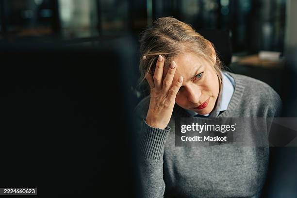 depressed senior businesswoman with head in hand at office - misserfolg stock-fotos und bilder