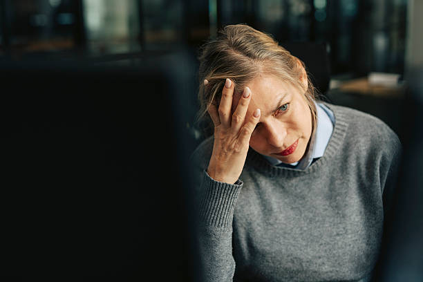 depressed senior businesswoman with head in hand at office - stress stock pictures, royalty-free photos & images