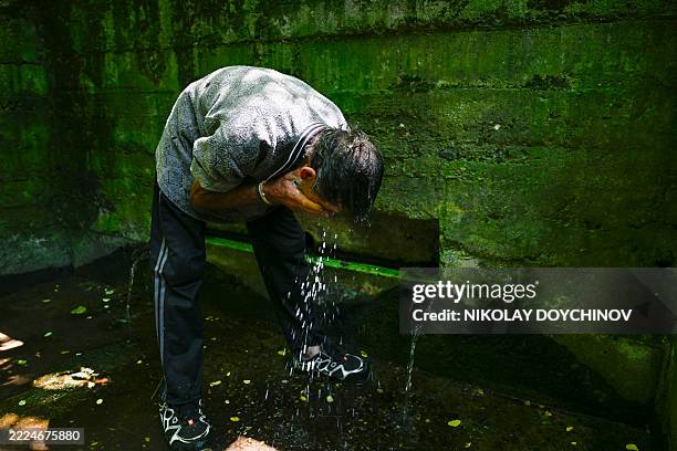 Villager Petyo Boyanov washes his face at a water source in the village of Gorna Studena, located near the Danube river, during a water shortage on...