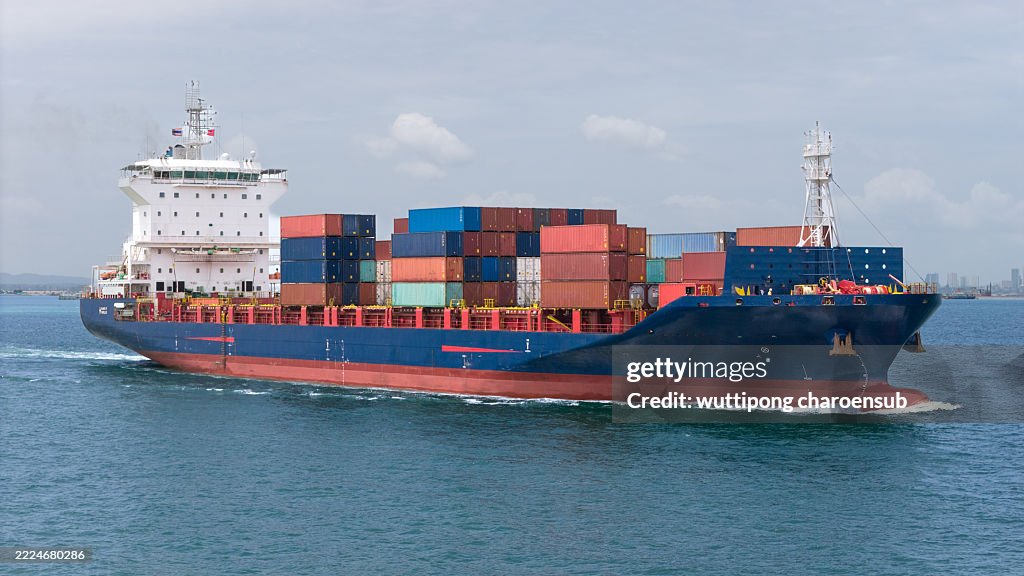 Top view Cargo Container ship with contrail in the ocean ship carrying container and running for import export concept technology freight shipping by ship.