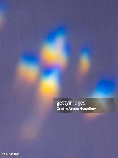 iridescent light leaks creating a dreamy, colorful bokeh effect on a purple background - prism photos et images de collection