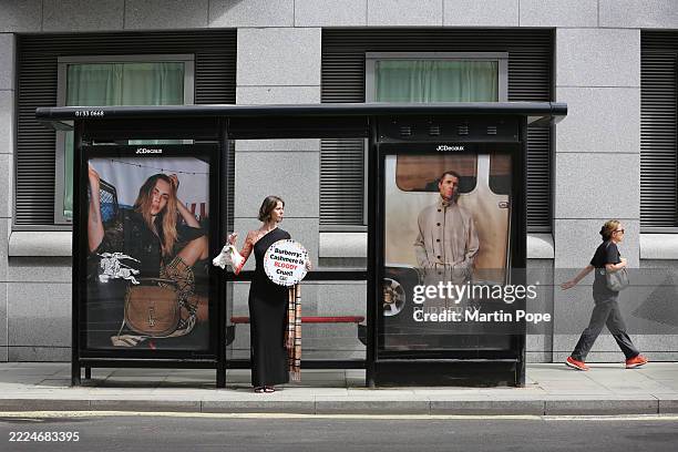 Model holds a model of a severed goat's head with fake blood and a sign saying 'Burberry: Cashmere is Bloody Cruel!' opposite Burberry HQ, at a...