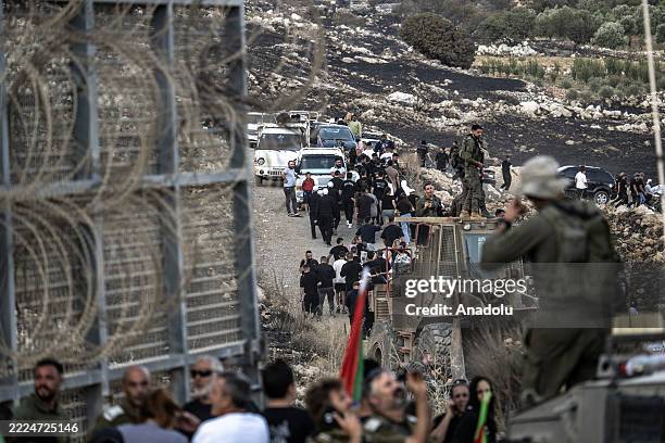Members of the Druze community gather near the barbed wire fence along the Golan Heights, close to the town of Majdal Shams, to stage a demonstration...
