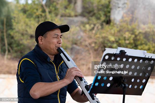 Mature amateur musician playing electronic wind instrument