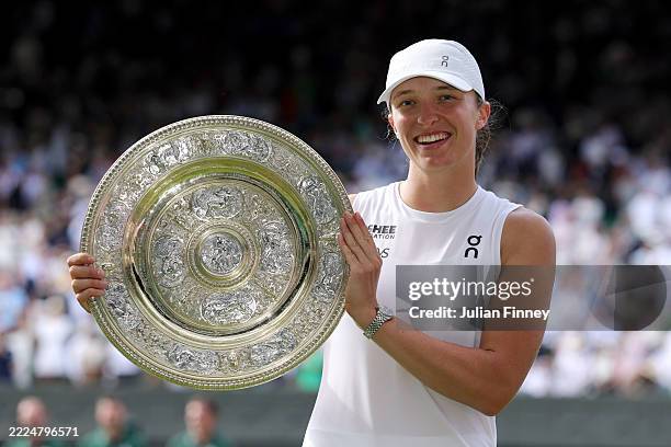 Iga Swiatek of Poland poses for a photo with the Ladies’ Singles Trophy following her victory against Amanda Anisimova of United States during the...